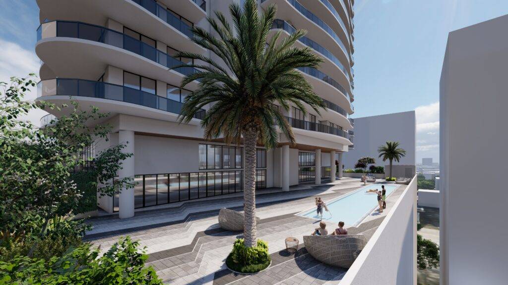 Modern high-rise building with poolside oasis and palm trees.