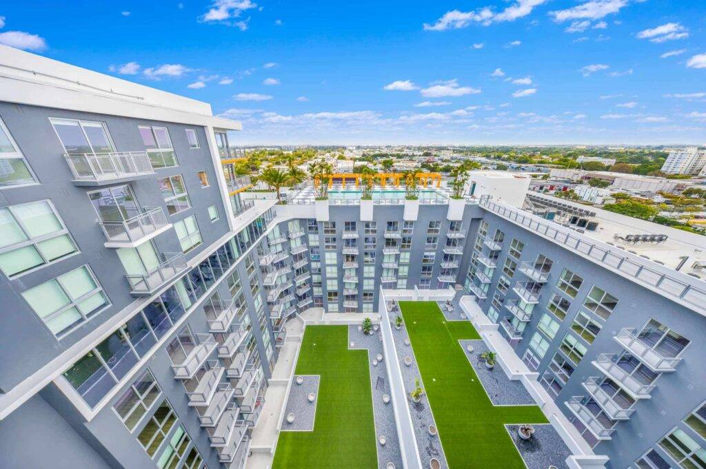 Modern high-rise residential building with a rooftop view overlooking the city skyline.