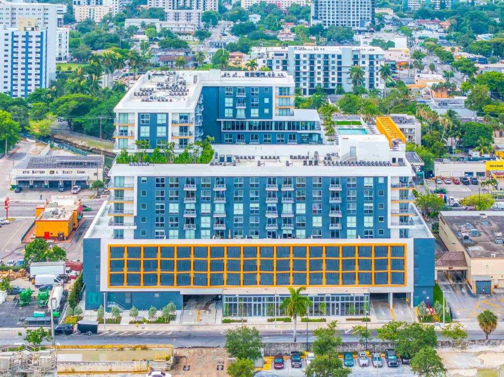 Aerial view of modern urban development with blue and orange buildings in a vibrant cityscape.