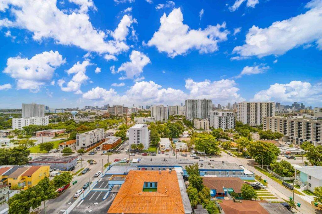 Vibrant aerial view of Allapattah with cityscape and lush greenery under a bright blue sky.