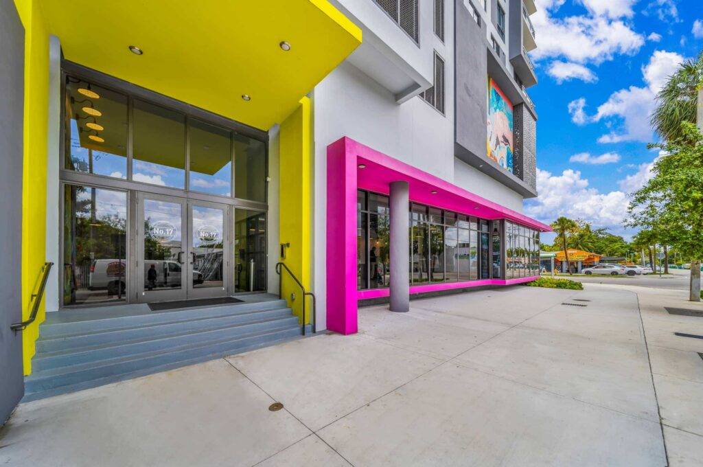 Vibrant building exterior with bright yellow and pink accents under a blue sky