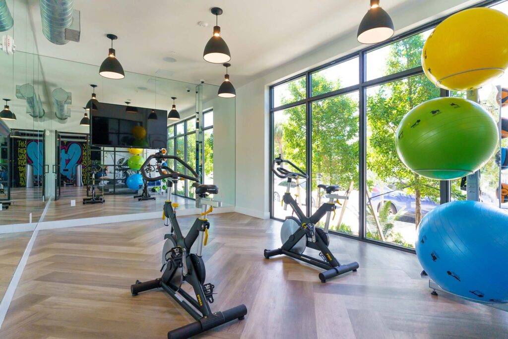 Modern fitness studio with exercise bikes and large windows for natural light.
