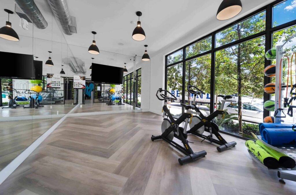 Modern fitness studio with exercise bikes and large windows offering a bright, inviting workout space.