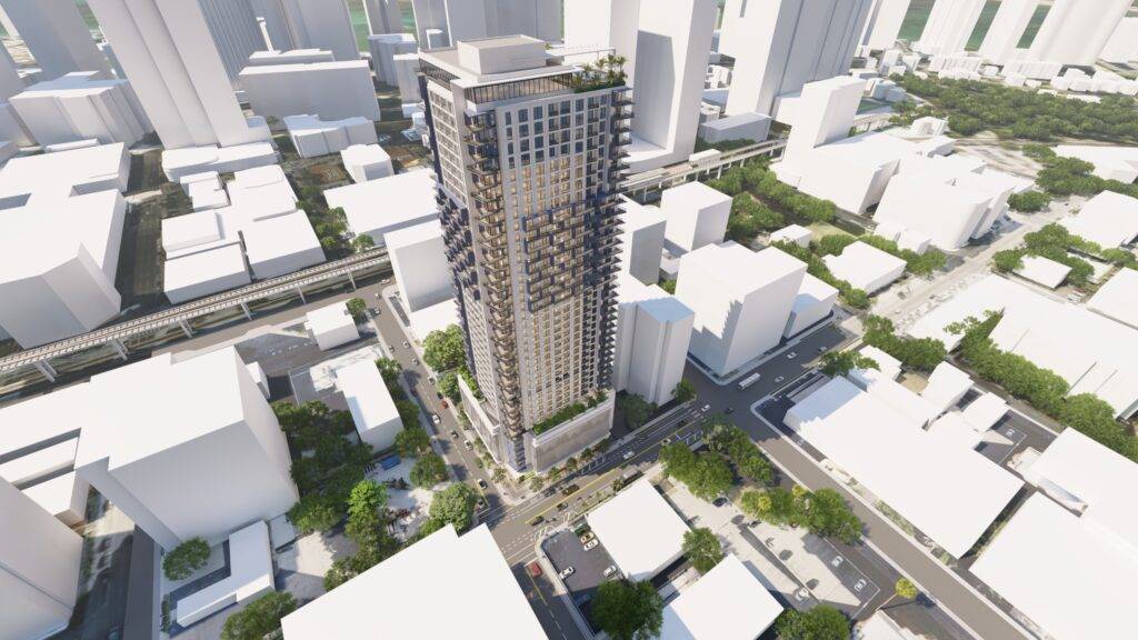 Aerial view of a modern high-rise building amongst cityscape with green spaces.