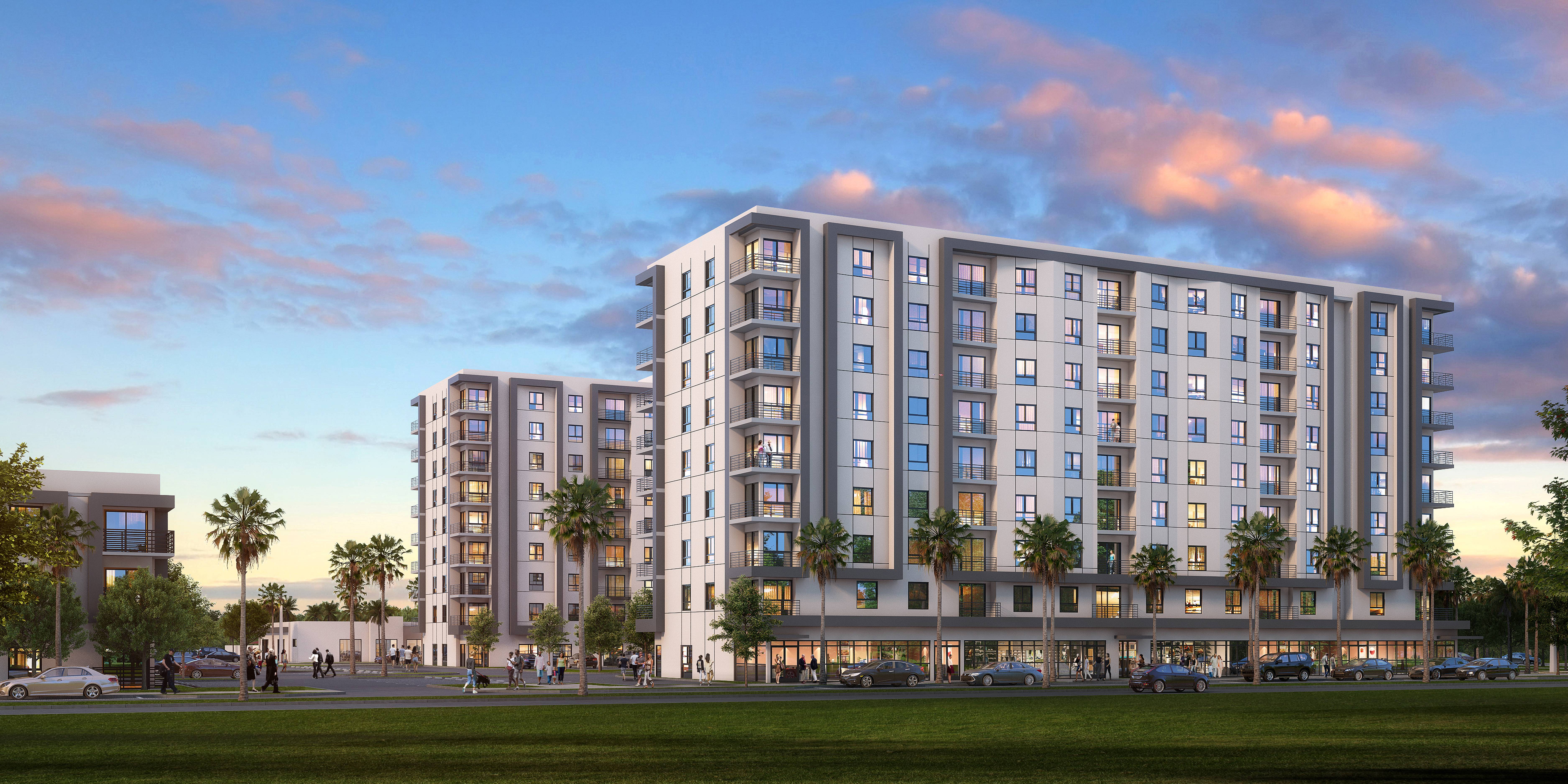 Modern apartment complex with palm trees at sunset
