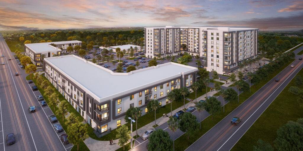 Aerial view of modern apartment complex surrounded by lush greenery at sunset.