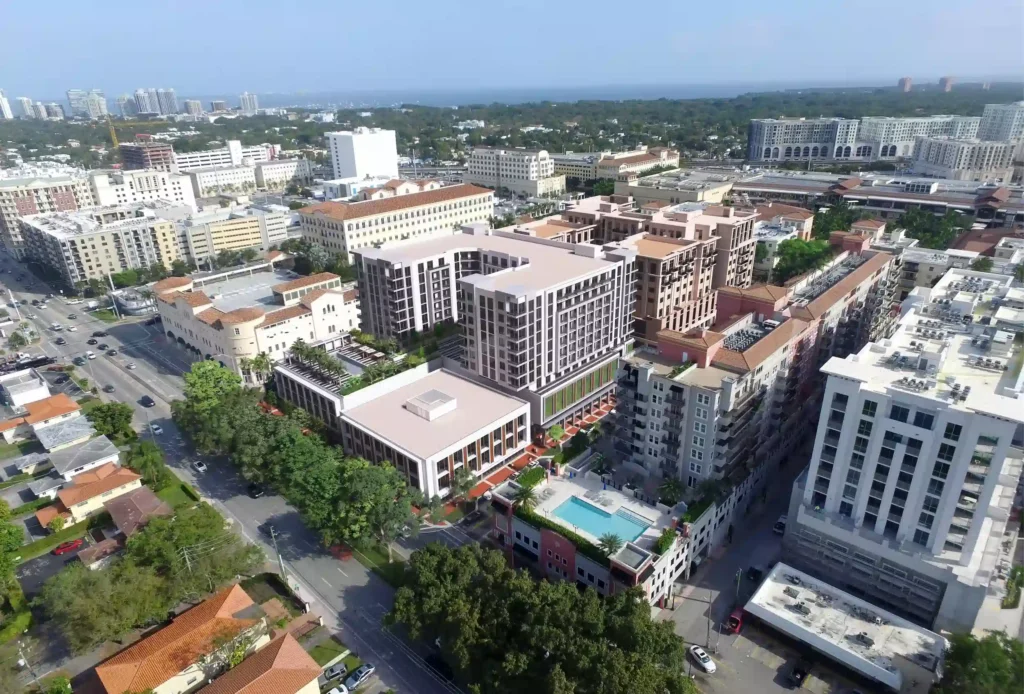 Aerial view of a modern cityscape with high-rise buildings and lush greenery.