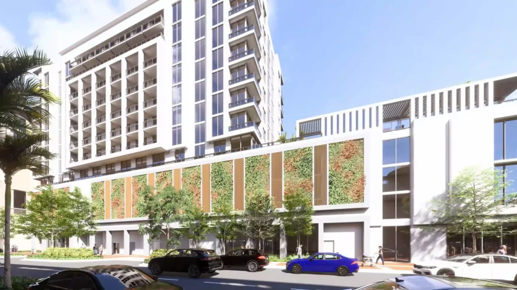 Modern urban building with green vertical garden and parked cars in a sunny cityscape.