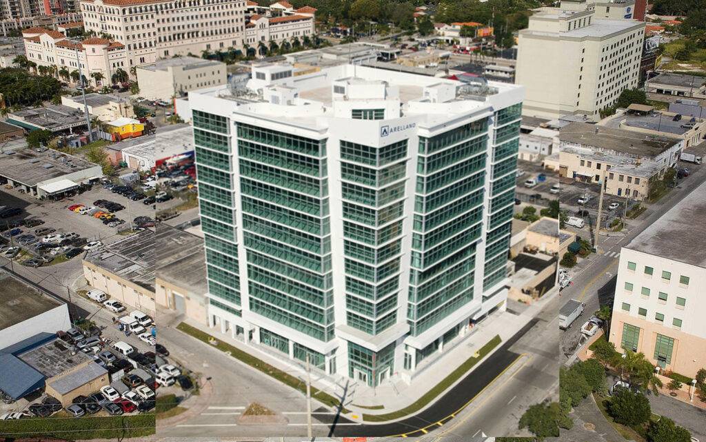 Aerial view of a modern office building surrounded by urban landscape and roads.