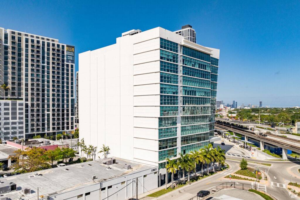 Modern office building in Coral Gables with glass façade and surrounding urban landscape.