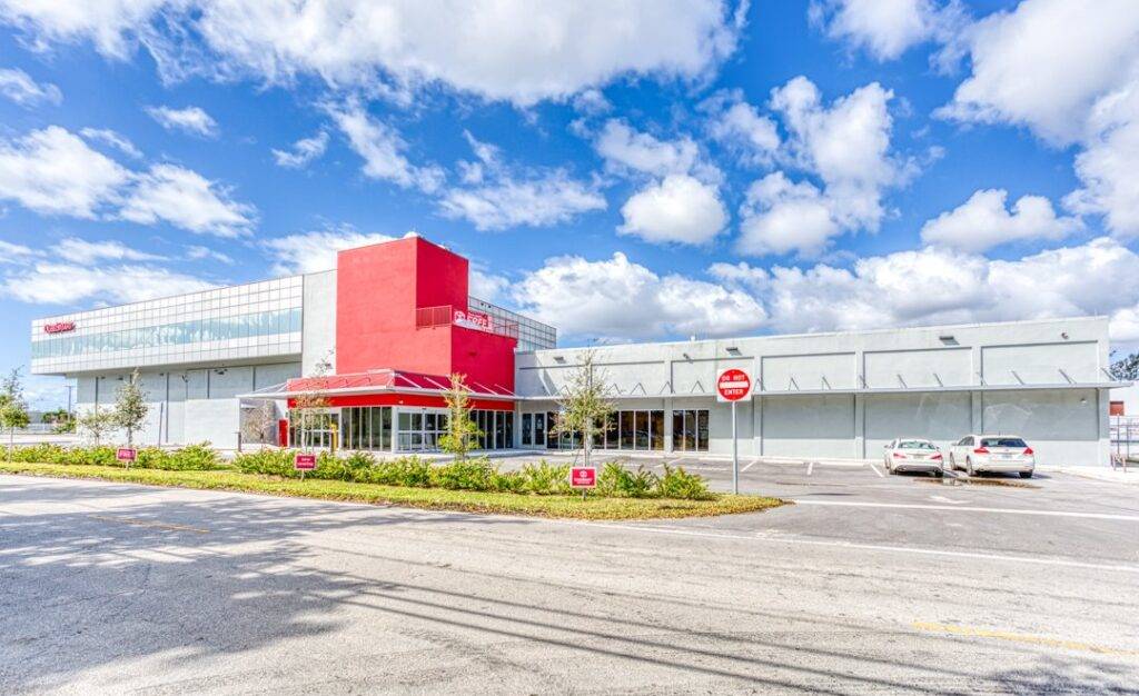 Modern warehouse facility under a bright blue sky.