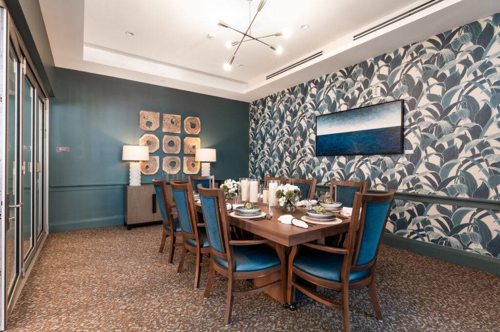 Elegant private dining room with blue and gold accents and floral wallpaper.