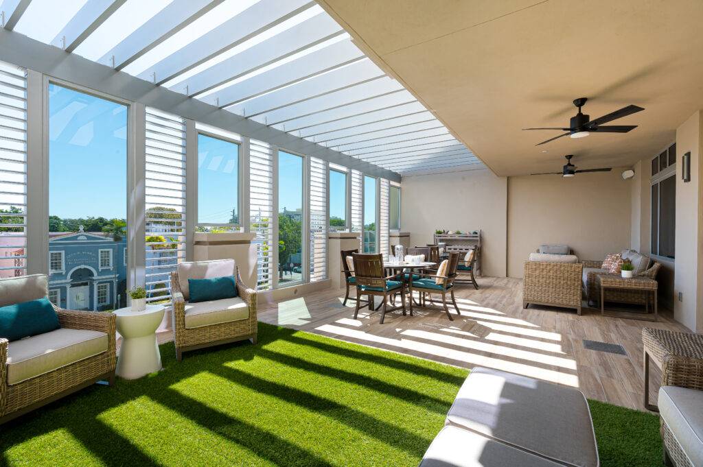 Spacious sunlit patio with stylish wicker seating and dining set in Coral Gables.