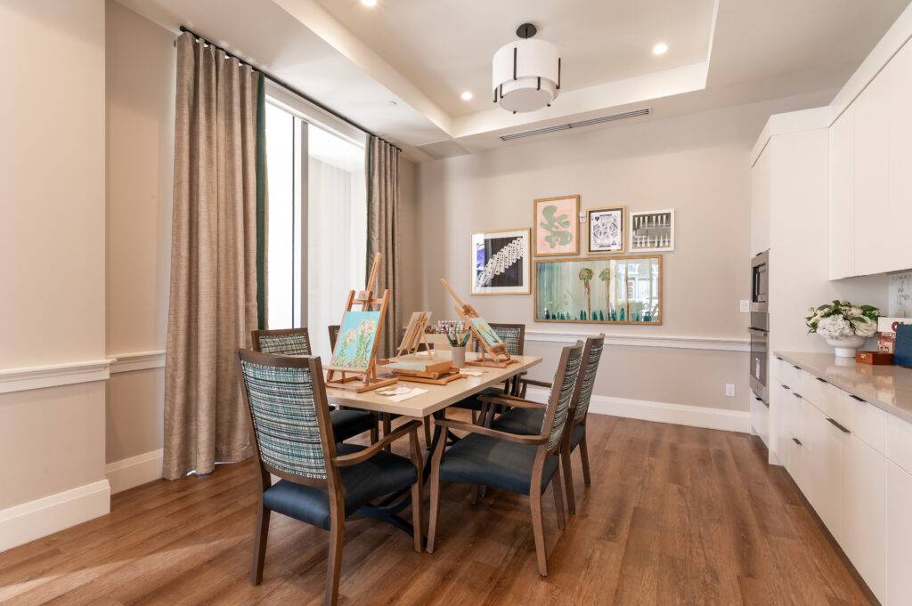 Elegant dining room with wooden floors, modern decor, and framed artwork on walls.