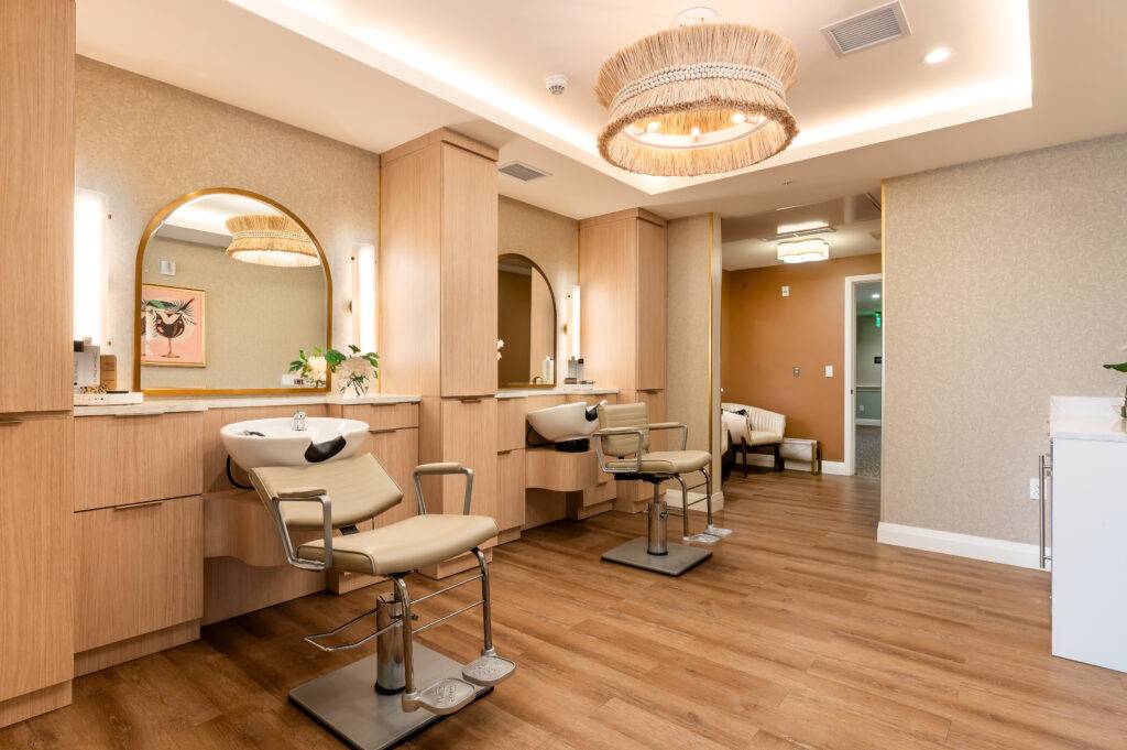 Elegant salon interior with two styling chairs, wooden flooring, and modern lighting in Coral Gables.