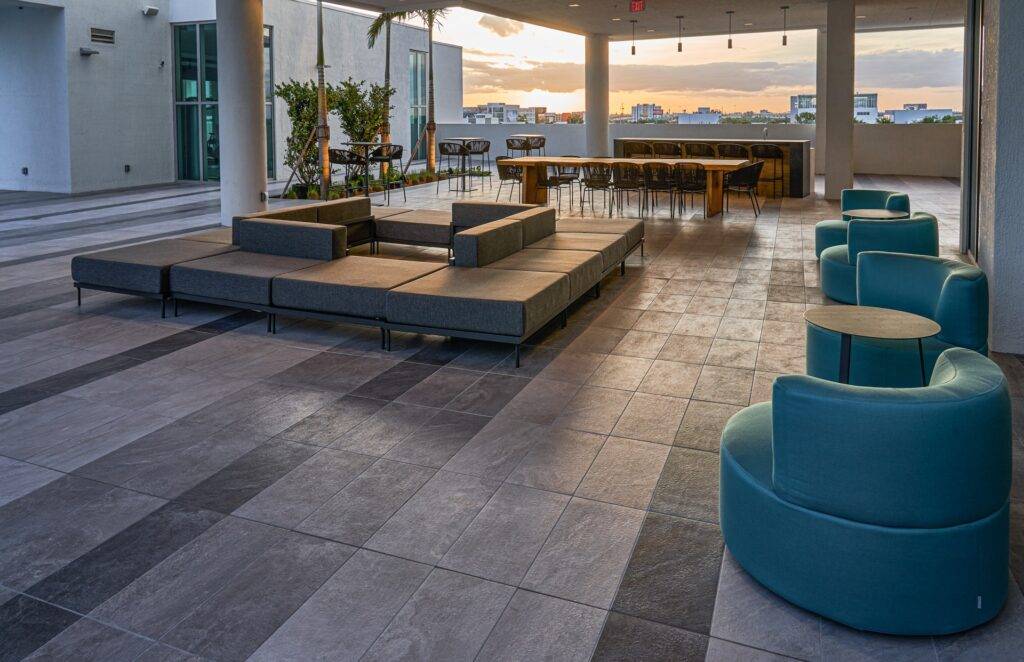 Rooftop lounge with modern seating, sunset view over the cityscape.
