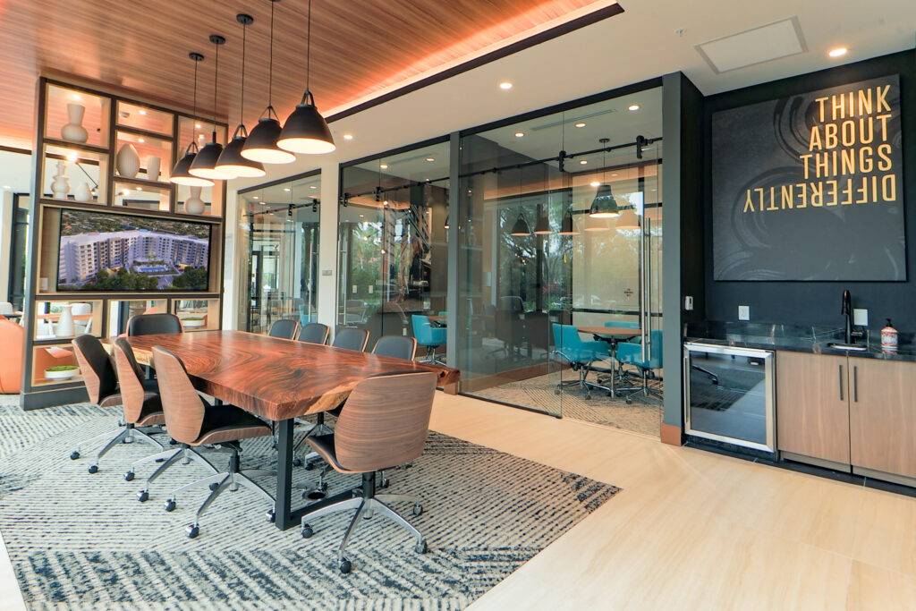 Modern meeting room with wooden table, stylish chairs, and motivational wall art.