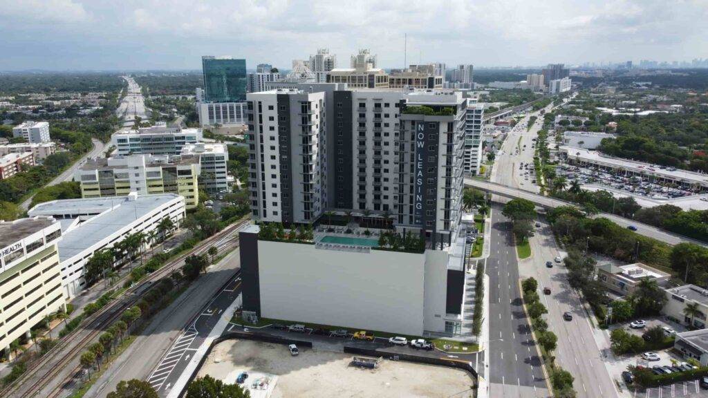 Aerial view of a modern high-rise building with an urban landscape in the background.