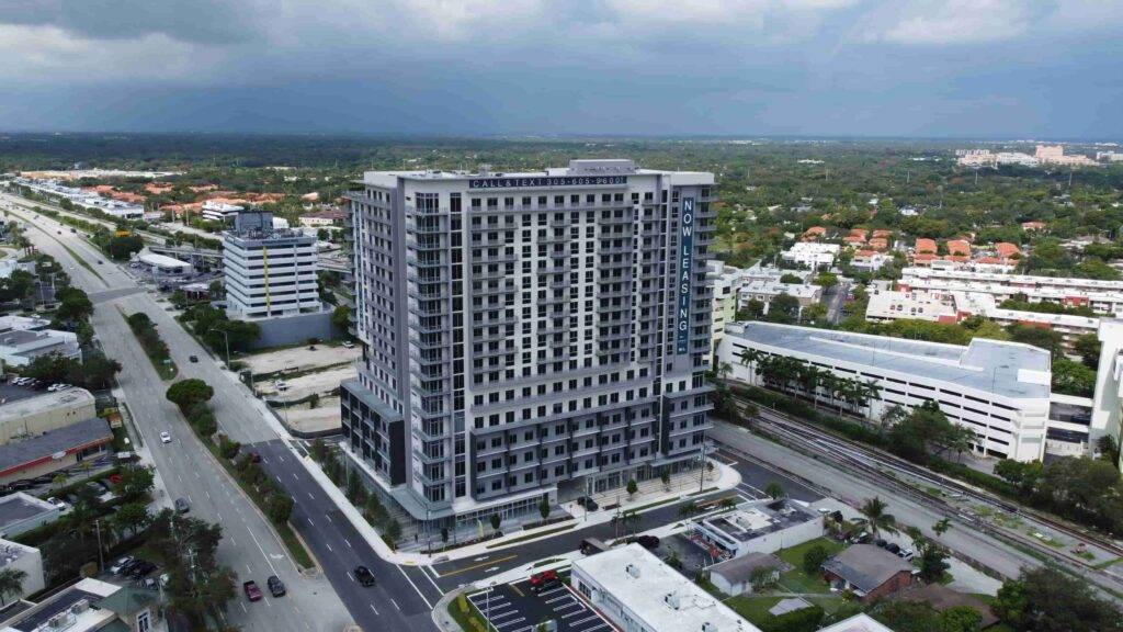 Modern high-rise building in an urban landscape under a cloudy sky.