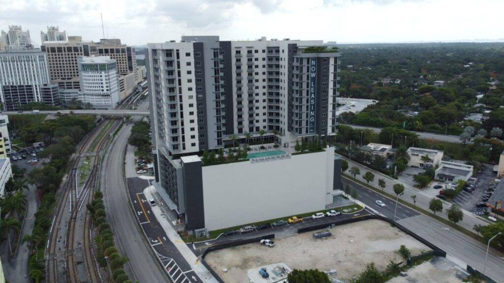 Modern high-rise building surrounded by lush greenery and urban landscape