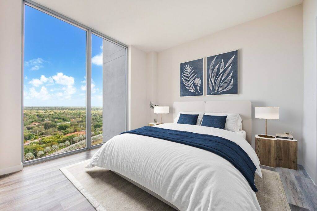 Modern bedroom with large window, scenic view, and stylish decor