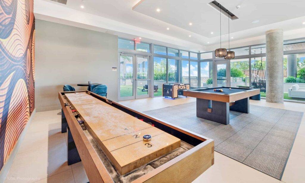 Modern game room with shuffleboard and pool table.