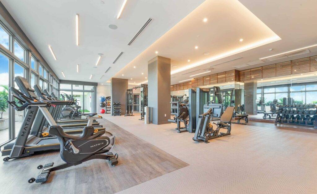 Modern fitness center with state-of-the-art gym equipment and large windows.