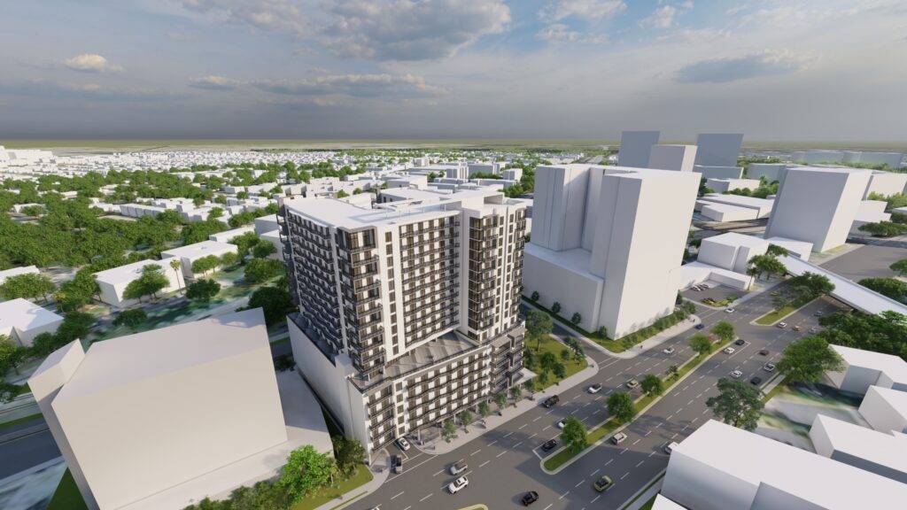 Aerial view of a modern high-rise building surrounded by city streets and greenery.