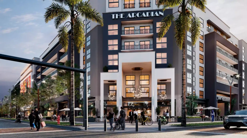 Modern urban building with illuminated windows and palm trees at The Arcadian.