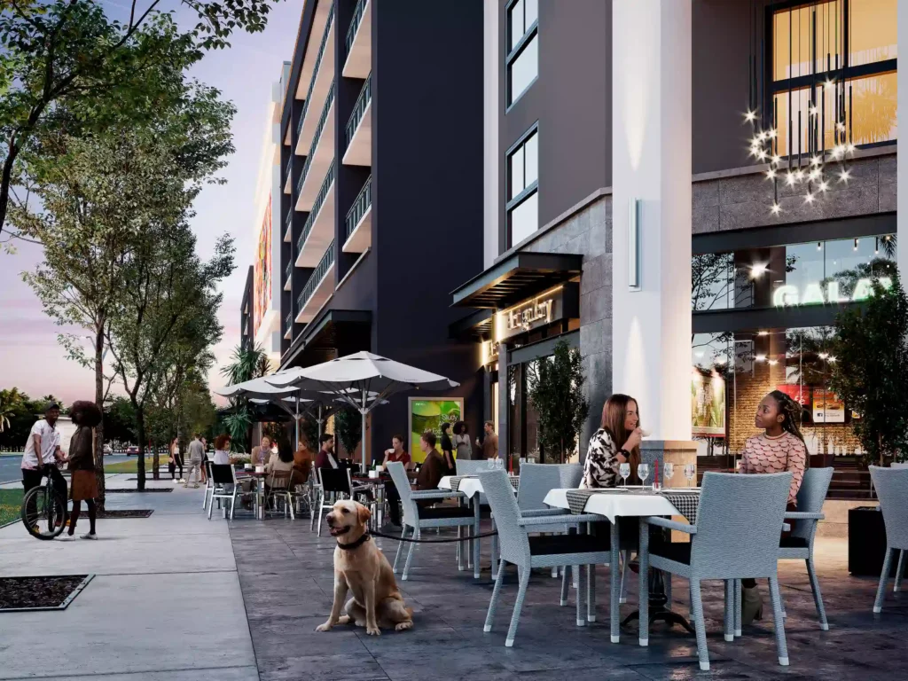 Outdoor dining scene with people enjoying meals at a stylish urban cafe on a tree-lined street during twilight.