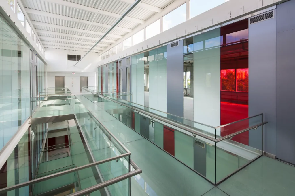 Modern office interior with glass walls and vibrant red accents at Optima Plaza.