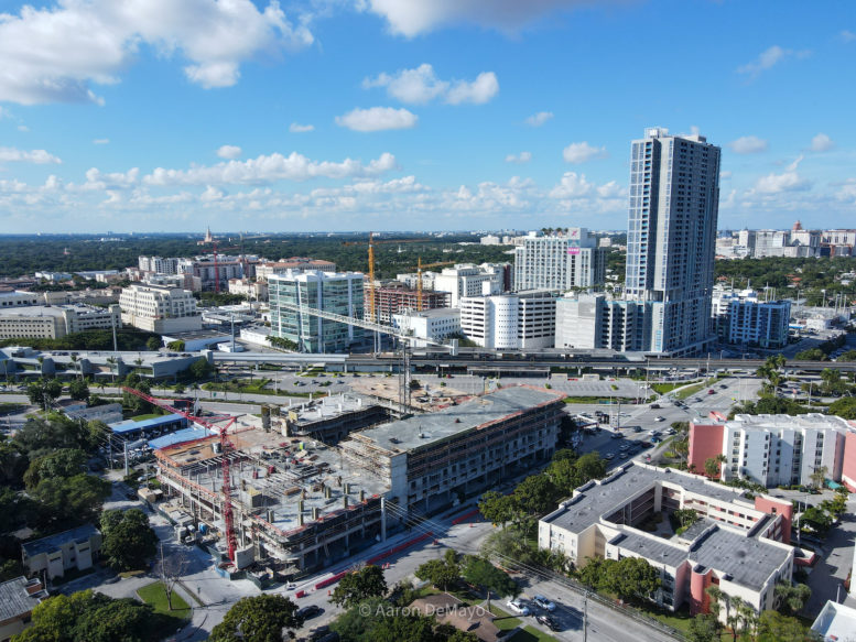 Urban landscape with high-rise buildings and construction site under a blue sky.