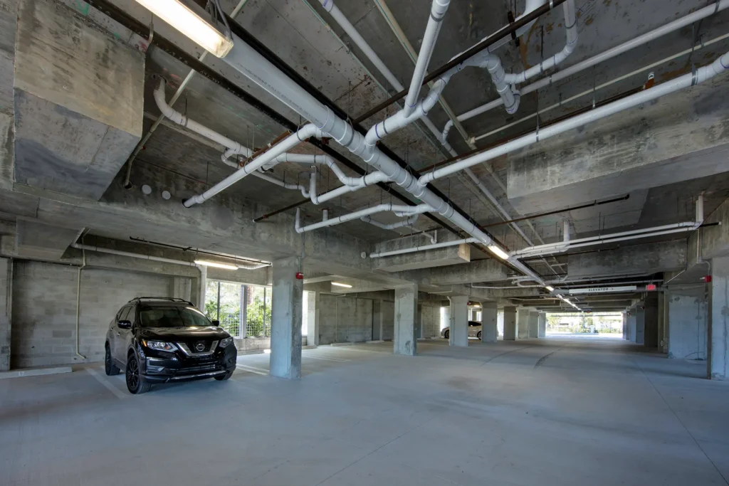 Spacious modern parking garage with industrial design and a single parked car.