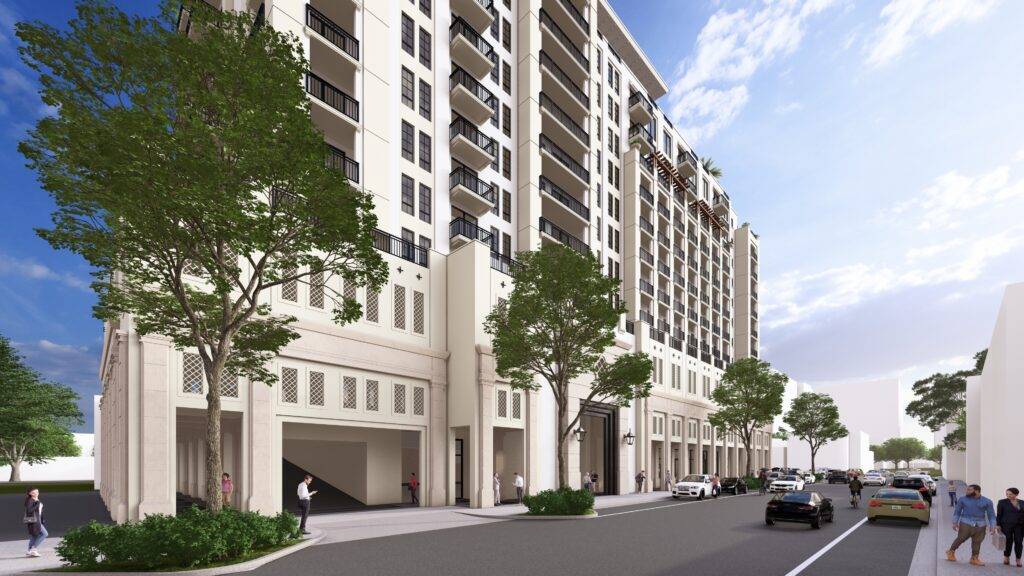 Modern white building with balconies, lined with trees on a city street.