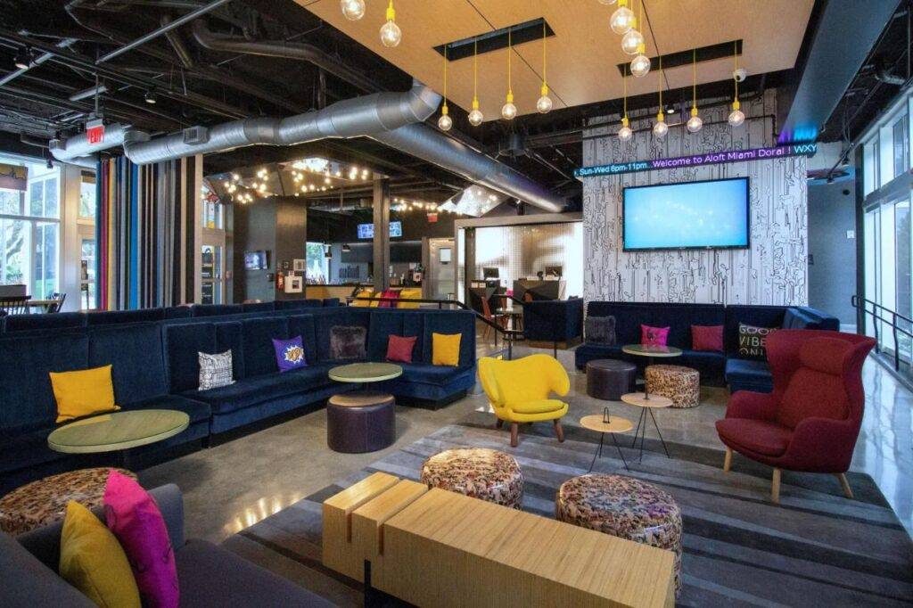 Modern hotel lobby with vibrant seating and ambient lighting.