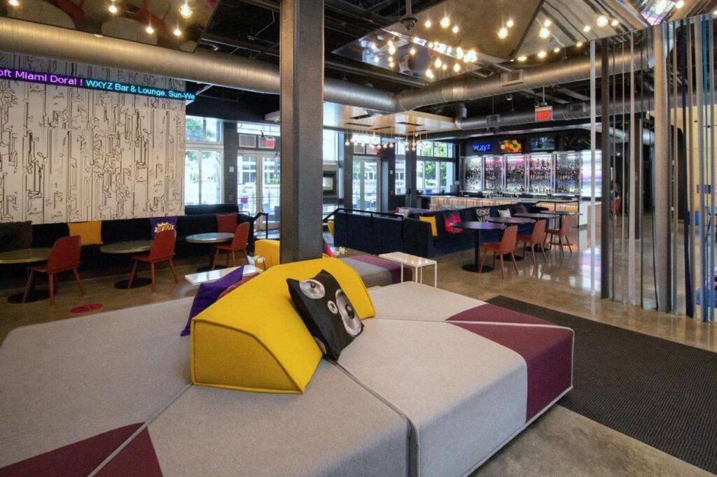 Modern seating area at a stylish Aloft hotel with colorful decor and contemporary design elements.