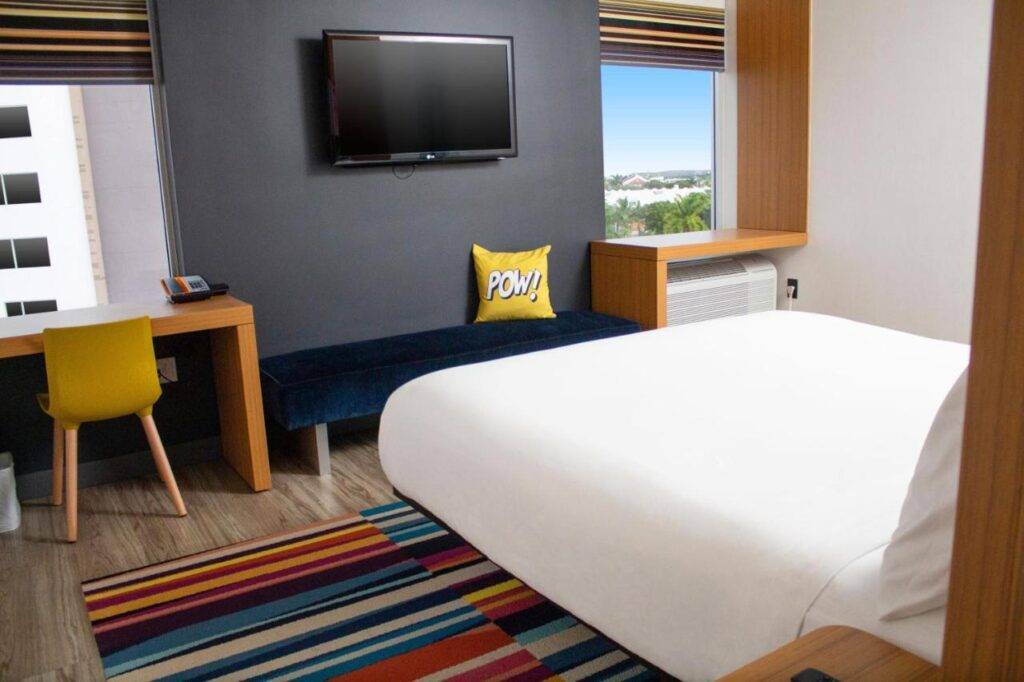 Modern hotel room with colorful decor and sleek furnishings.