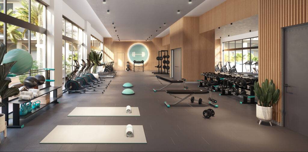 Modern gym with exercise equipment, weights, and large windows.