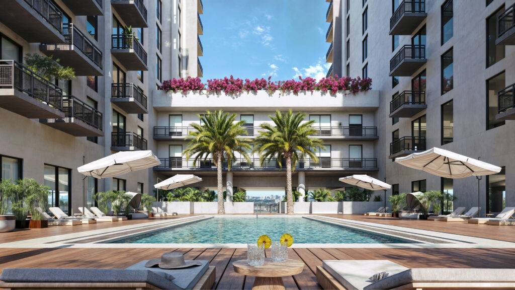 Luxurious apartment complex with a sunlit pool, surrounded by palm trees and elegant balconies.