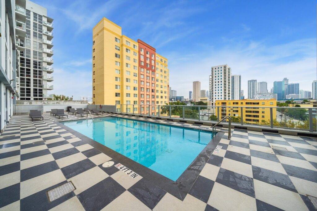 Rooftop pool in a modern urban setting with city skyline views.
