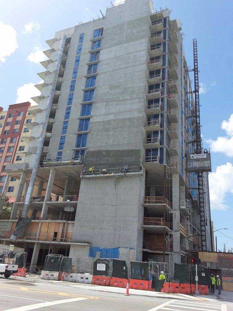 High-rise building under construction in an urban setting with clear blue skies.