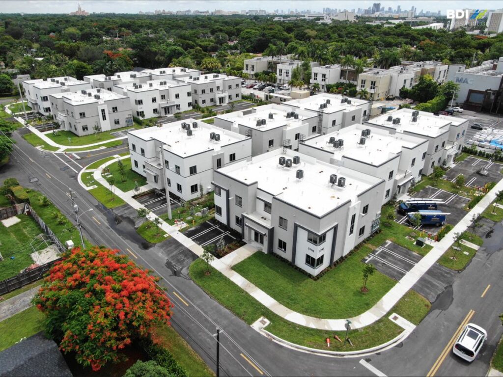 Aerial view of a modern townhome complex surrounded by lush greenery.