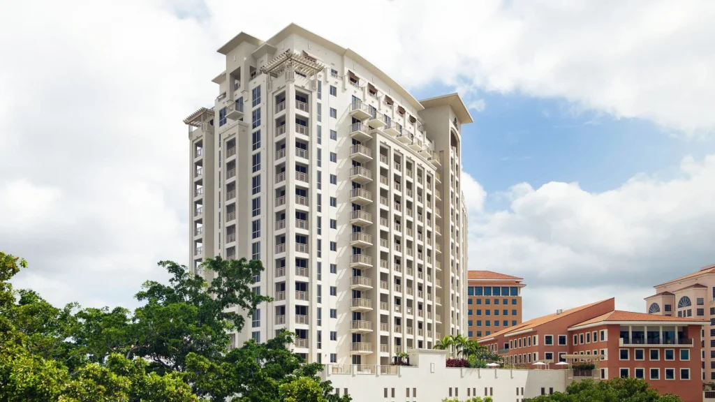 Tall white building with classical architecture against a partly cloudy sky.