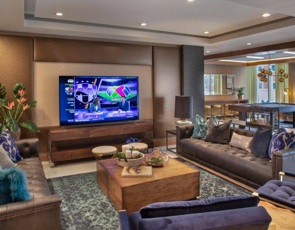 Modern living room with sleek furniture and large TV.