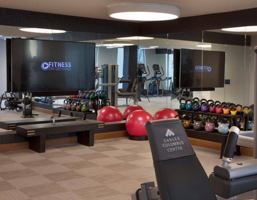 Modern gym interior with fitness equipment and large mirrors in Columbus Center.