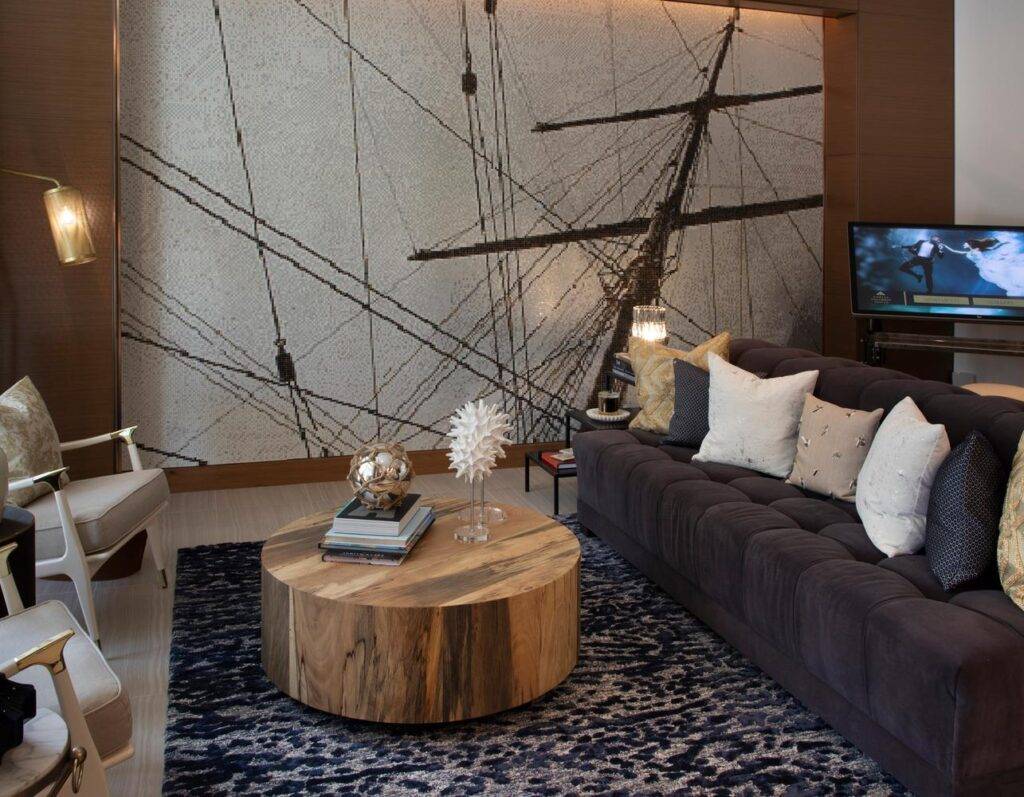 Modern living room with abstract ship mural, wooden coffee table, and cozy gray sofa.