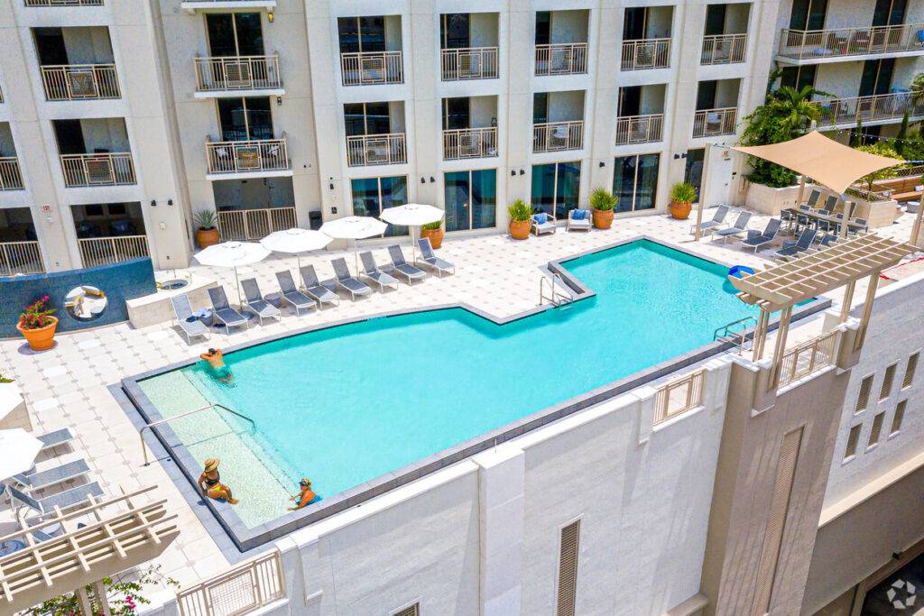 Rooftop pool with lounge chairs and umbrellas at a modern hotel