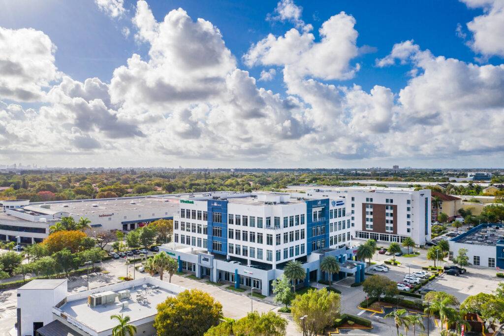 Aerial view of Doral Park Centre featuring modern architecture amid lush greenery under a partly cloudy sky.
