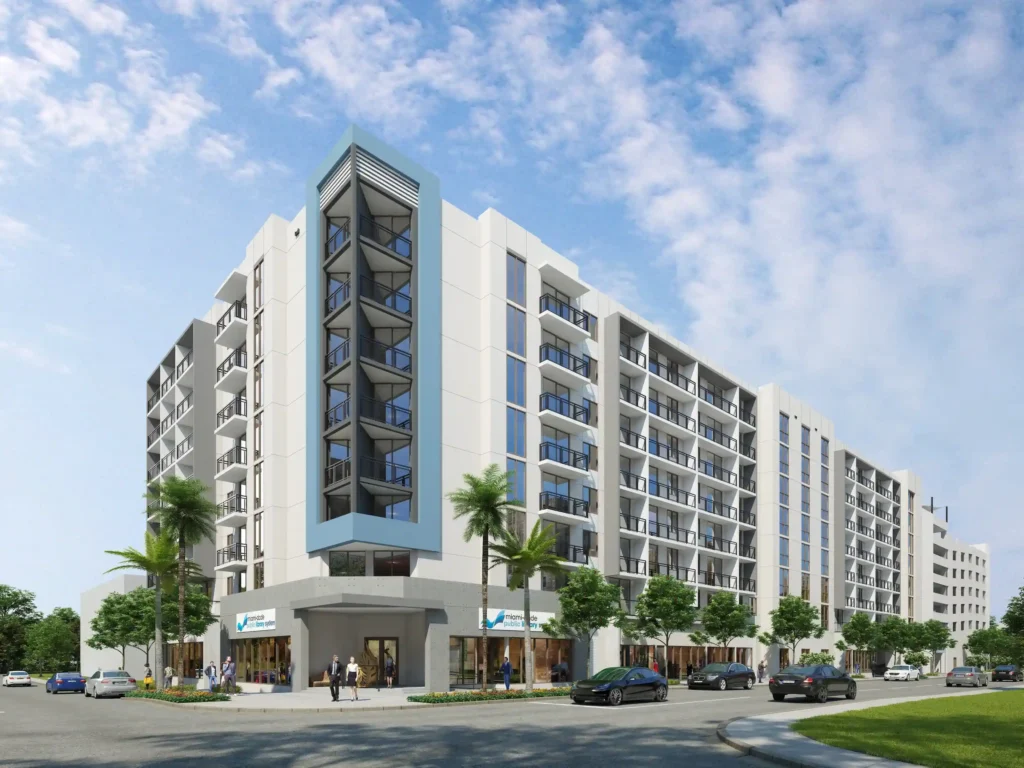 Modern apartment complex under clear skies with palm trees and parked cars, showcasing urban architecture.