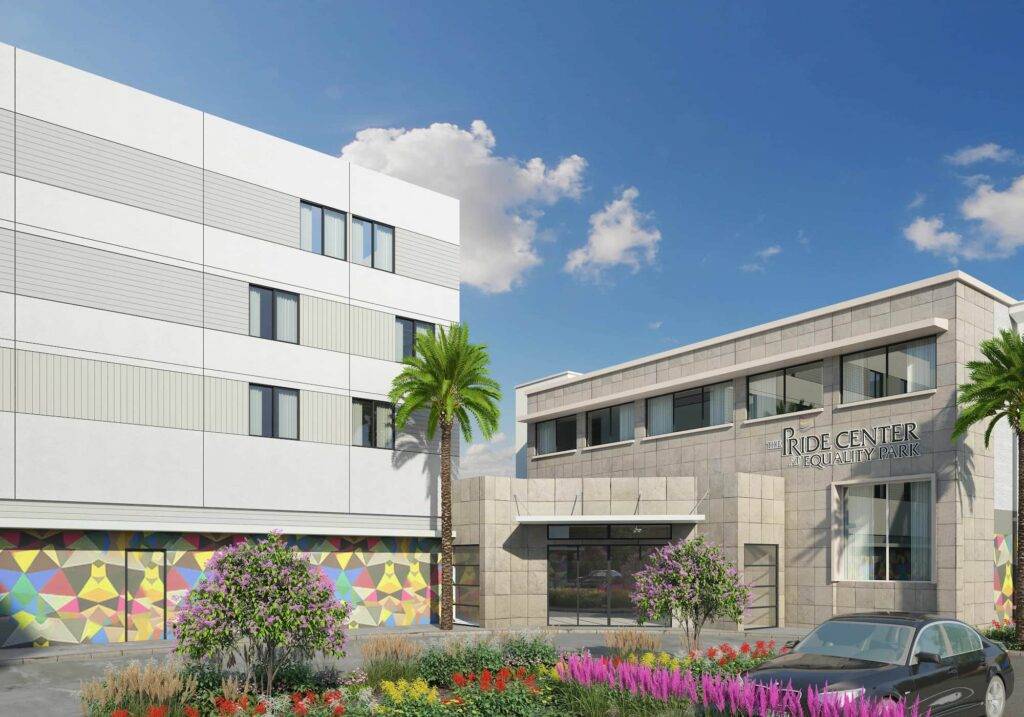 Modern building facade with colorful mural and lush garden in urban setting.